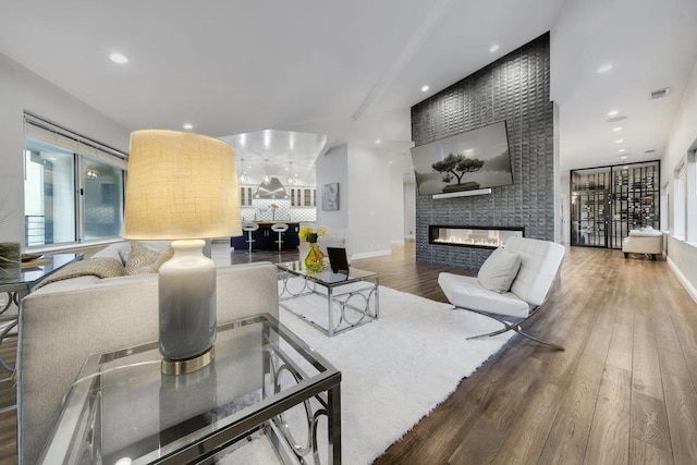 living room featuring a large fireplace and hardwood / wood-style flooring