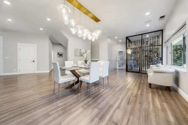 dining area featuring light hardwood / wood-style floors and a chandelier