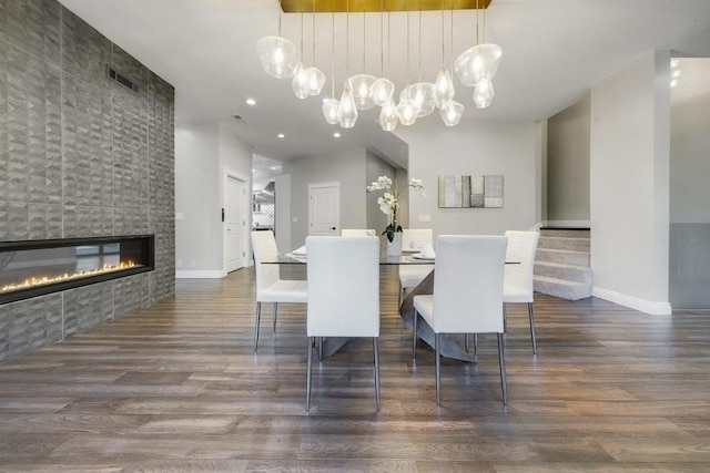 dining space featuring dark wood-type flooring and a tile fireplace