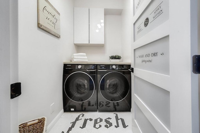 washroom with cabinets, light tile patterned floors, and washing machine and clothes dryer