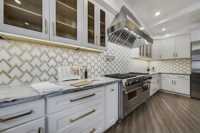 kitchen with high quality appliances, white cabinets, dark hardwood / wood-style floors, island range hood, and light stone counters