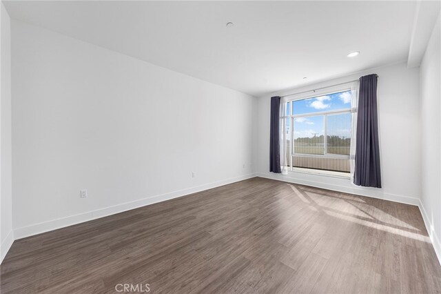 empty room with dark hardwood / wood-style flooring