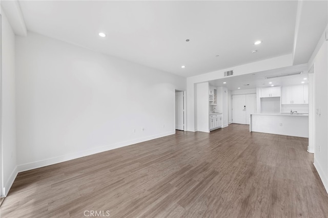 unfurnished living room with wood-type flooring