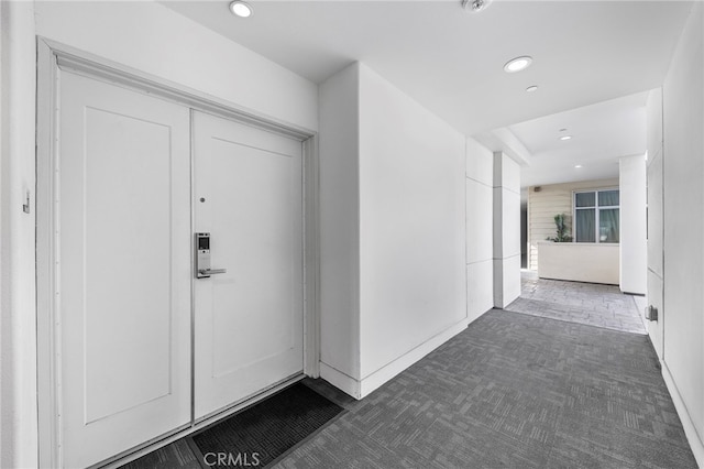 entryway featuring dark colored carpet