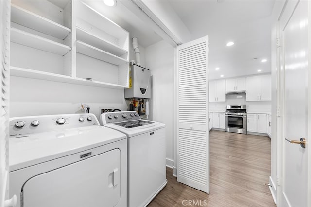 laundry area with hardwood / wood-style flooring, tankless water heater, and independent washer and dryer