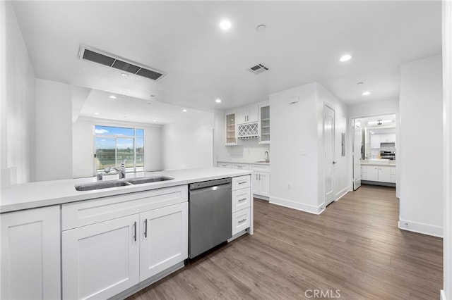 kitchen featuring white cabinetry, dishwasher, sink, and hardwood / wood-style flooring