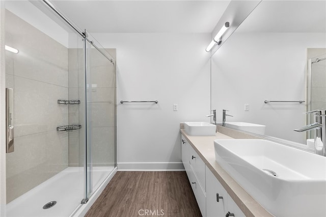 bathroom with a shower with door, hardwood / wood-style flooring, and vanity