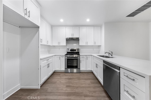 kitchen featuring appliances with stainless steel finishes, light wood-type flooring, sink, and white cabinets