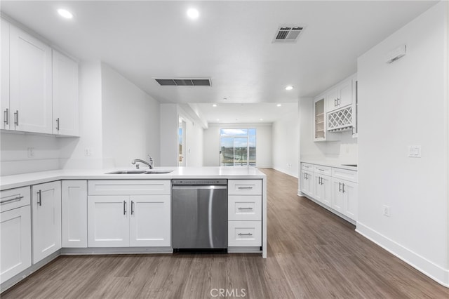 kitchen with wood-type flooring, dishwasher, sink, white cabinetry, and kitchen peninsula