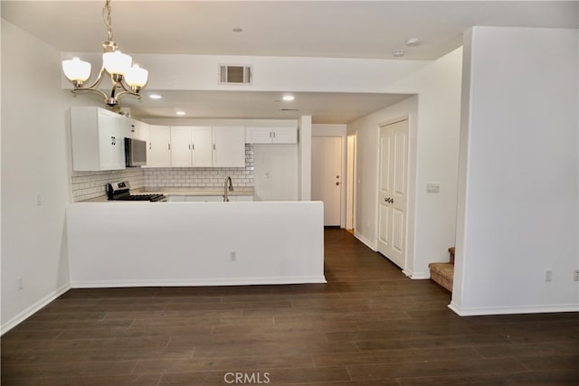 kitchen featuring stainless steel appliances, dark hardwood / wood-style floors, kitchen peninsula, and white cabinetry