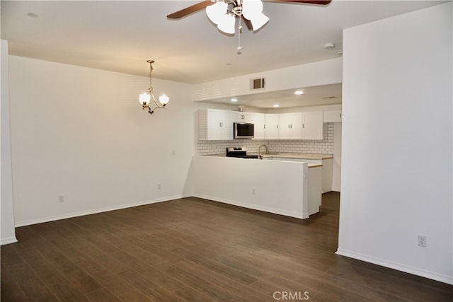 kitchen featuring white cabinetry, ceiling fan with notable chandelier, kitchen peninsula, stainless steel appliances, and dark hardwood / wood-style floors