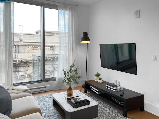 living room featuring dark wood-type flooring and a baseboard heating unit