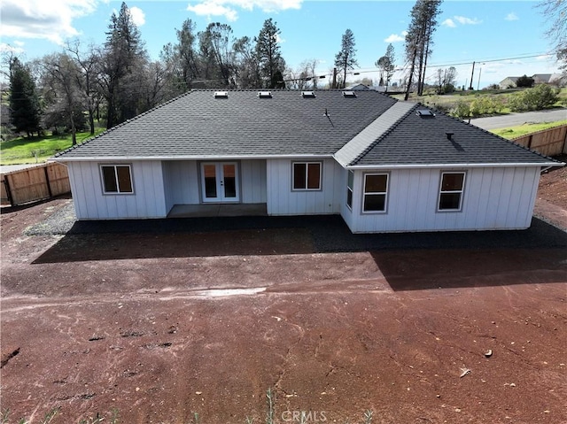 view of front of house with french doors, roof with shingles, and fence