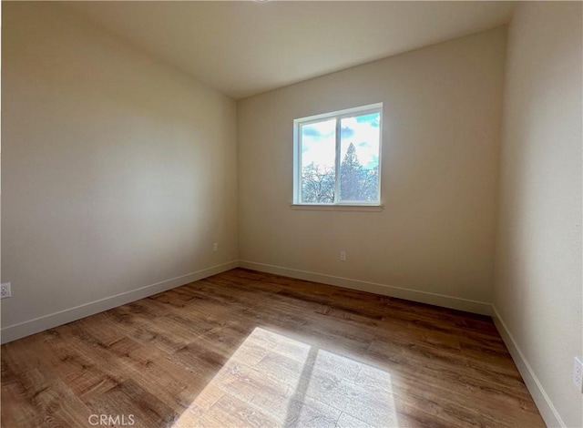 spare room with wood finished floors and baseboards