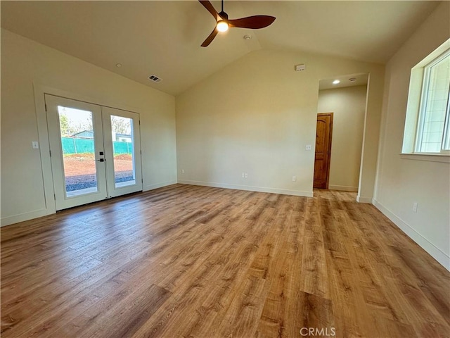 empty room with visible vents, light wood-style flooring, a ceiling fan, french doors, and lofted ceiling