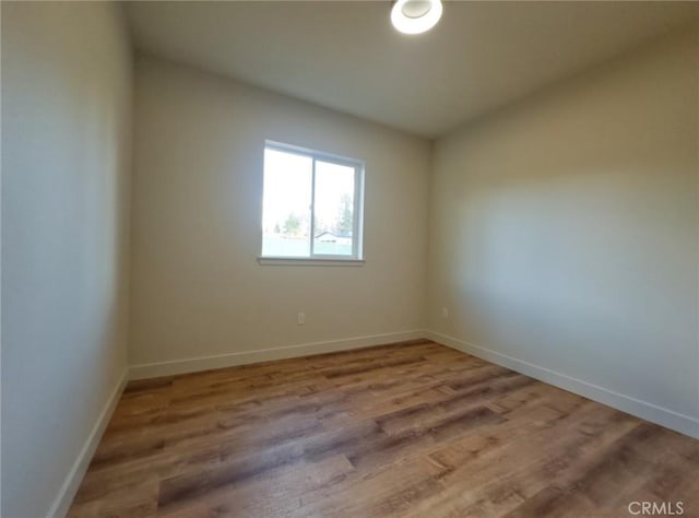 empty room with wood finished floors and baseboards