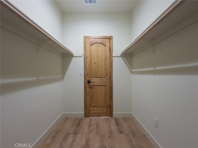 spacious closet featuring visible vents and wood finished floors