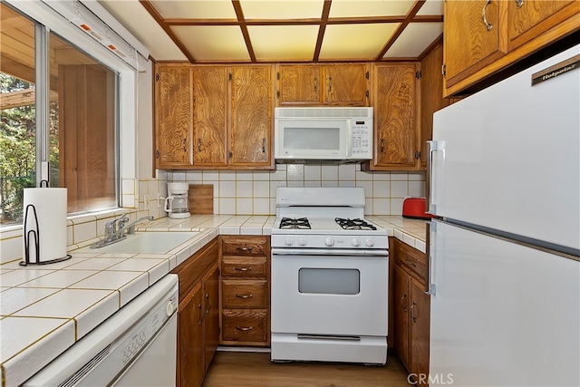 kitchen featuring sink, backsplash, white appliances, tile countertops, and dark hardwood / wood-style flooring