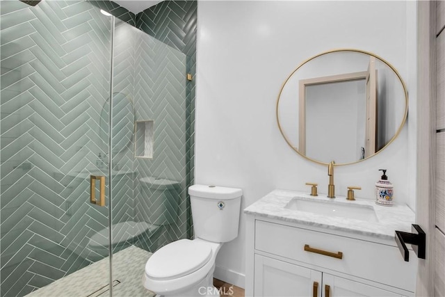 bathroom featuring vanity, toilet, and a shower with shower door