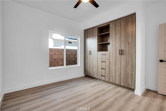 unfurnished bedroom with ceiling fan, light wood-type flooring, and a closet