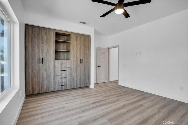 unfurnished bedroom with ceiling fan, a closet, and light wood-type flooring