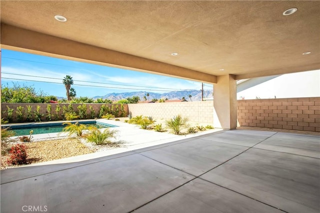 view of patio featuring a fenced in pool and a mountain view