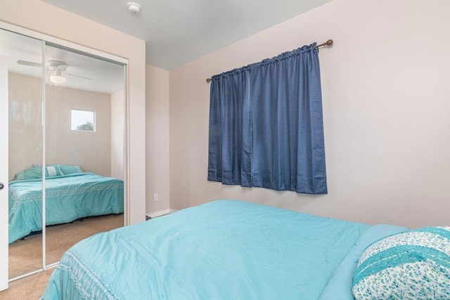 carpeted bedroom with ceiling fan and a closet