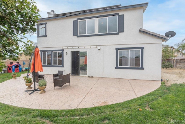 rear view of property with a yard and a patio