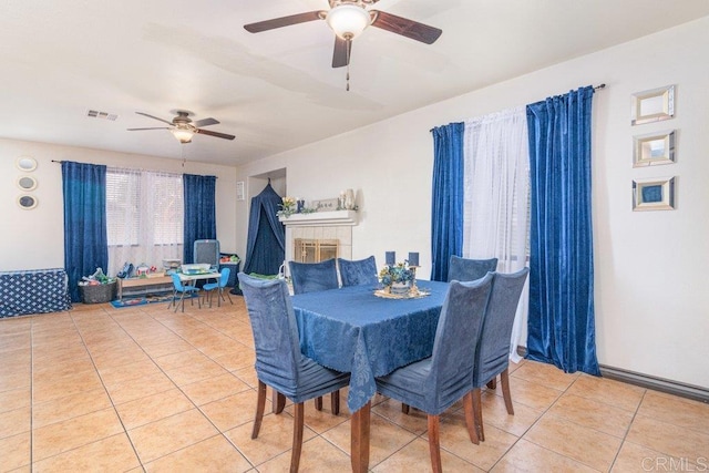 tiled dining space featuring ceiling fan