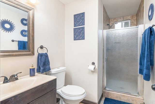 bathroom featuring tile patterned floors, vanity, toilet, and a shower with door