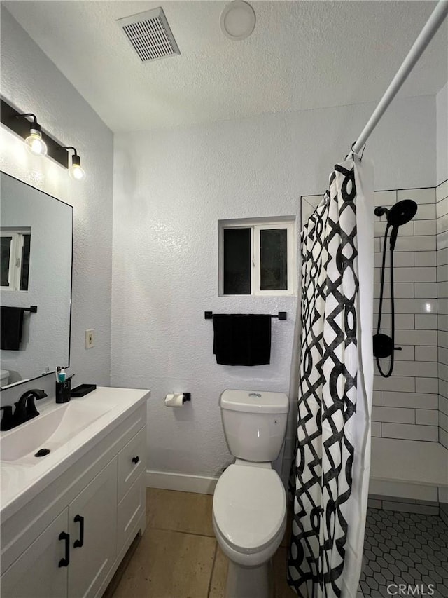 bathroom with tile patterned floors, vanity, a textured ceiling, toilet, and curtained shower