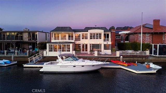 back house at dusk featuring a water view