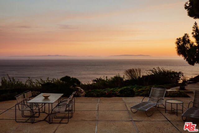 patio terrace at dusk with a water and mountain view