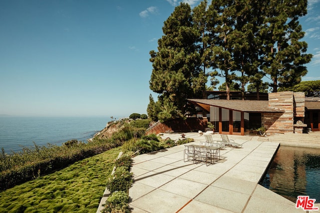 view of patio / terrace with a pool and a water view