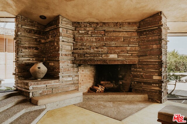 living room with lofted ceiling and an outdoor stone fireplace