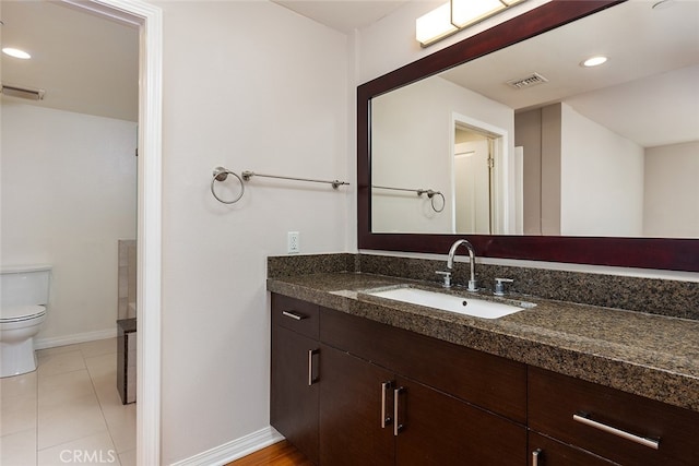 bathroom with tile patterned flooring, vanity, and toilet