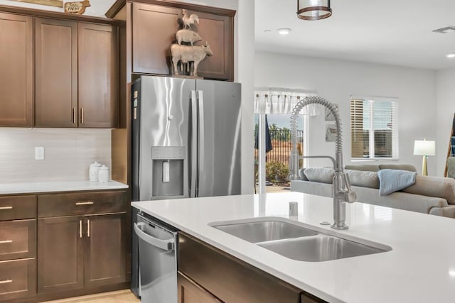 kitchen featuring backsplash, sink, dark brown cabinetry, and appliances with stainless steel finishes