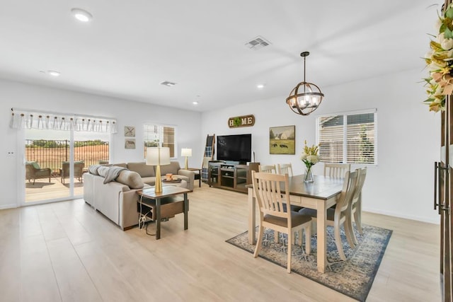 dining area with a chandelier, a healthy amount of sunlight, and light hardwood / wood-style flooring