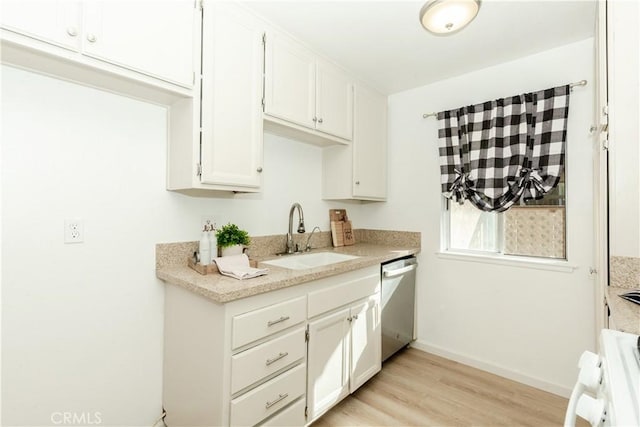 kitchen with light wood-type flooring, white cabinets, sink, dishwasher, and range