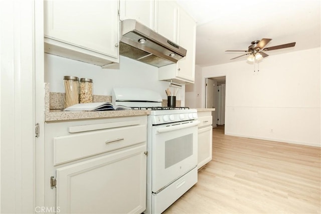 kitchen with white cabinets, light hardwood / wood-style flooring, white gas range, and ceiling fan