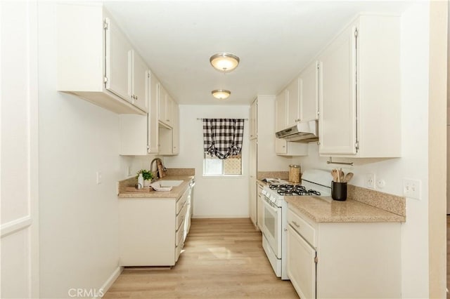 kitchen with white cabinets, white range with gas stovetop, sink, and light hardwood / wood-style flooring