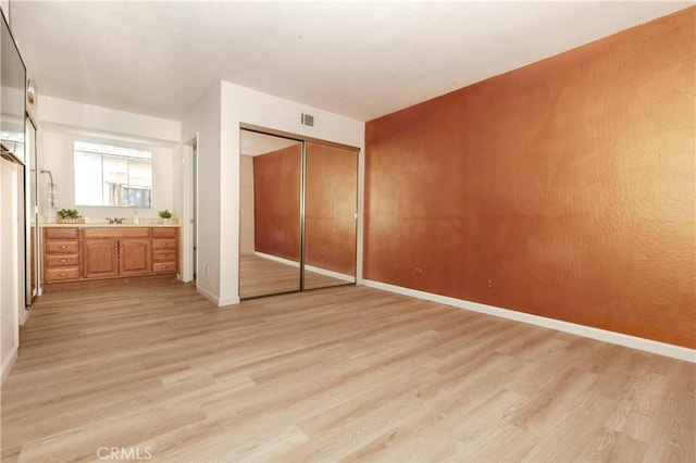 unfurnished bedroom featuring light hardwood / wood-style floors and a closet