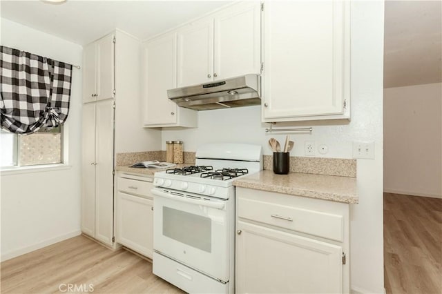 kitchen with white cabinets, light wood-type flooring, and white gas range