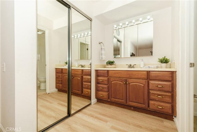 bathroom with vanity, hardwood / wood-style flooring, and toilet