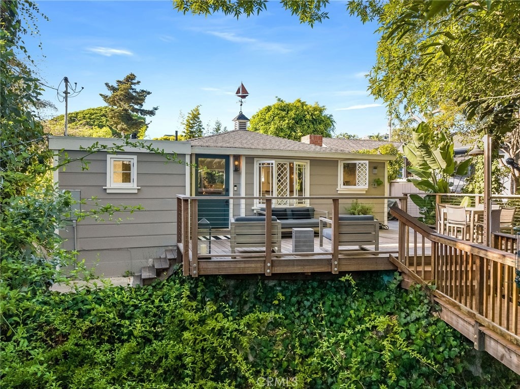 rear view of house featuring a wooden deck and an outdoor hangout area