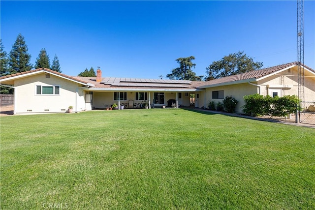 view of front of home featuring a front yard and solar panels