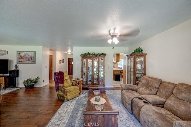 living room with dark wood-type flooring and ceiling fan