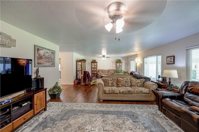 living room with dark hardwood / wood-style floors, a textured ceiling, and ceiling fan