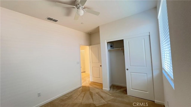 unfurnished bedroom with light carpet, a closet, and ceiling fan