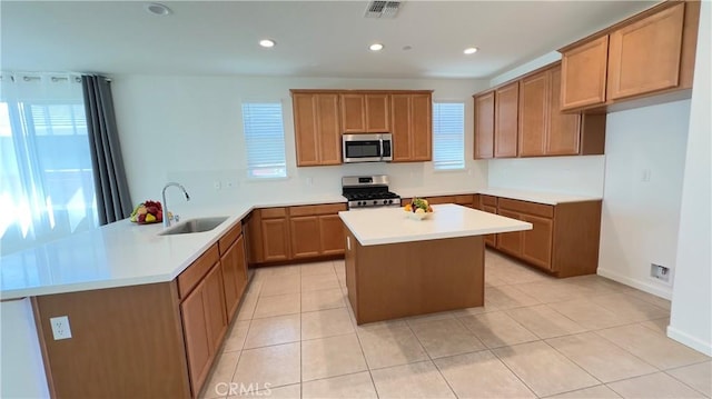 kitchen featuring sink, a center island, light tile patterned floors, kitchen peninsula, and stainless steel appliances